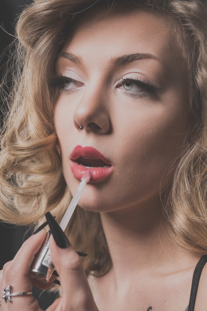 Mia trägt Lipgloss auf, Beauty-Nahaufnahme im Studio