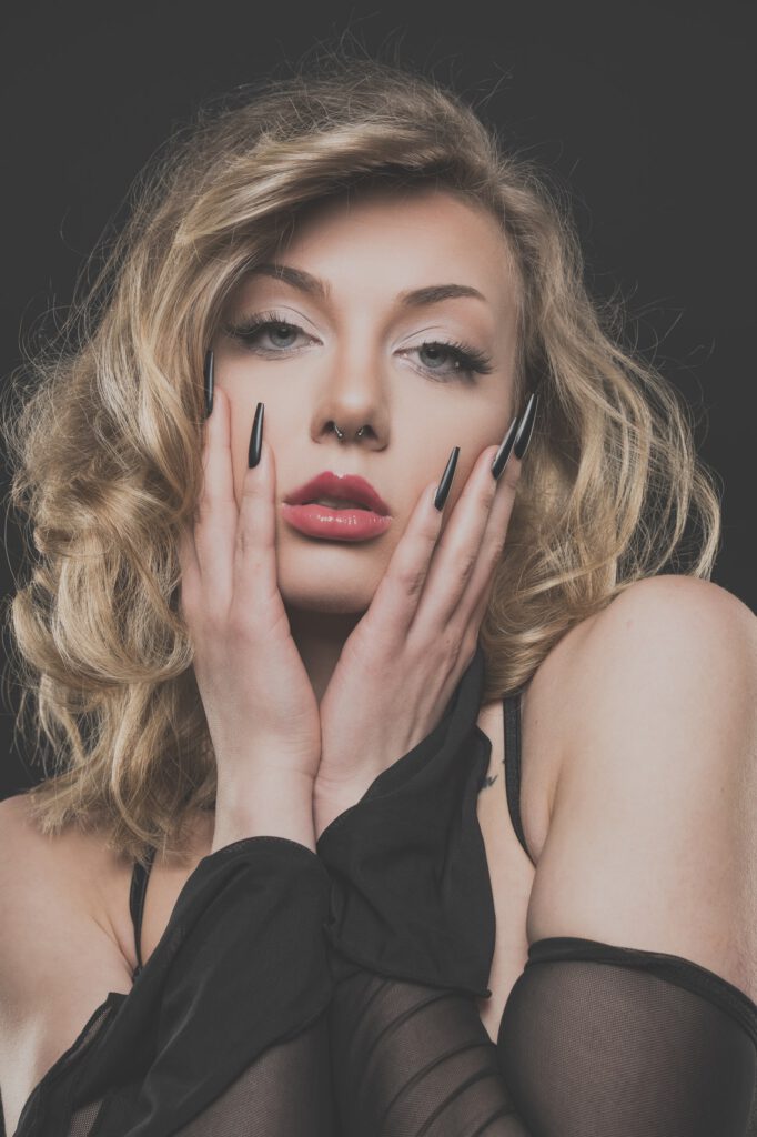 Mia mit den Händen am Gesicht, Beauty-Porträt mit schwarzen Krallennägeln