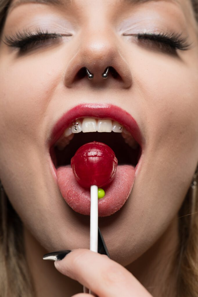 Mia mit einem Lolli im Mund, verspielte Beauty-Nahaufnahme