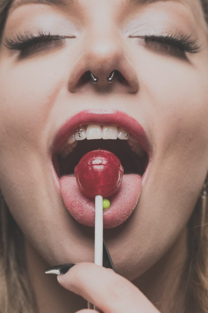 Mia mit einem Lolli im Mund, verspielte Beauty-Nahaufnahme
