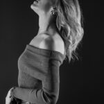 Schwarz-Weiß-Portrait von Alina im Studio: Seitenansicht mit in den Nacken gelegtem Kopf, schulterfreier Strickpullover