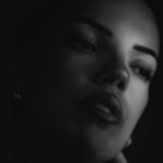 Schwarz-Weiß-Portrait von Lilly im Studio: Nahaufnahme im Halbdunkel, Licht auf Lippen und Wange