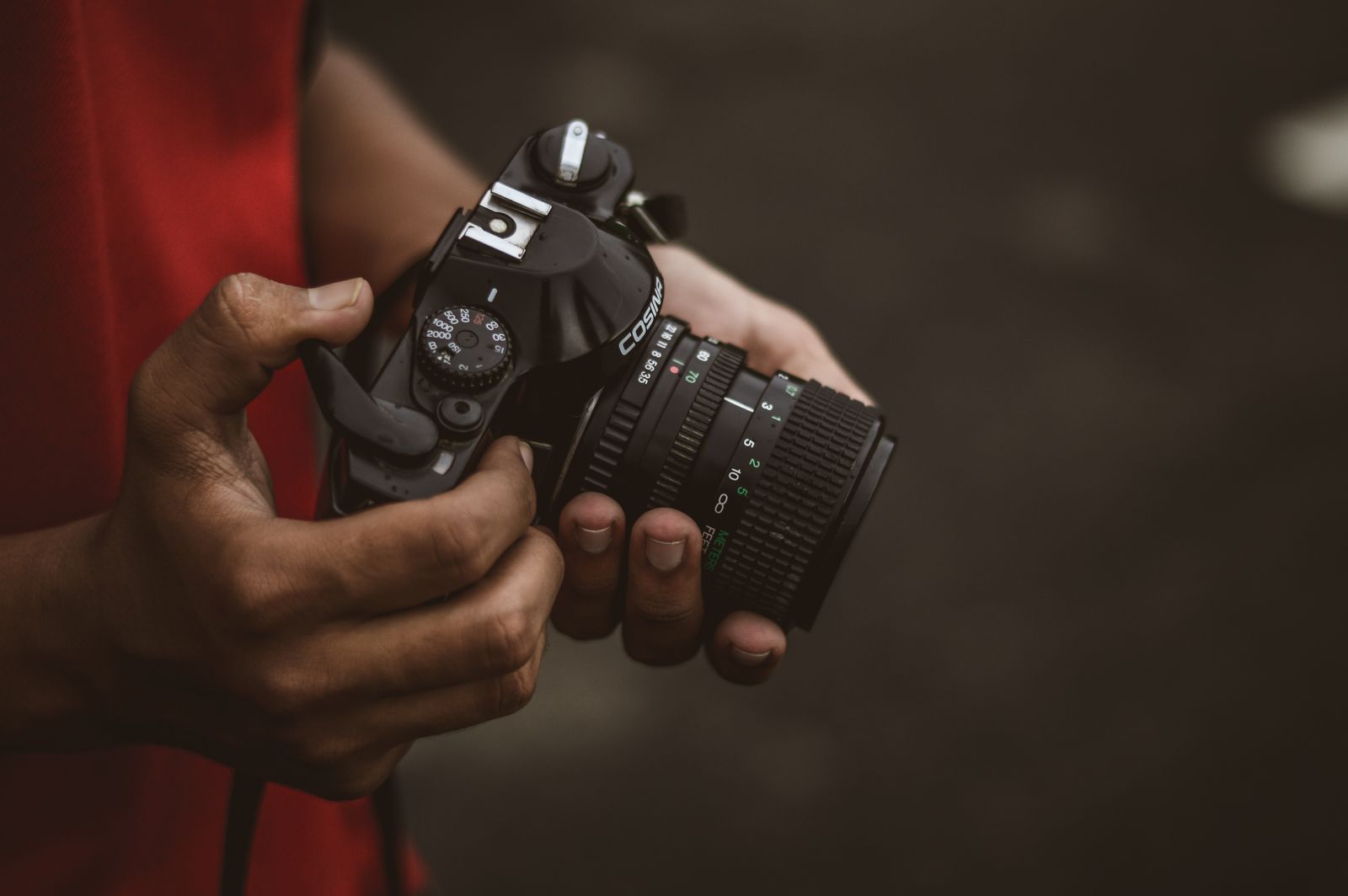 Fotograf haelt eine Kamera in der Hand